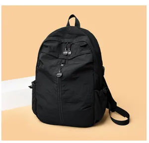 Black casual backpack detail view featuring durable fabric, multiple zippers and straps.