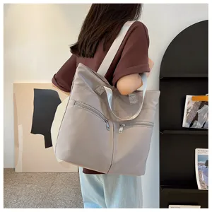 Detail view of casual grey nylon tote bag, featuring double zipper pockets and large capacity.