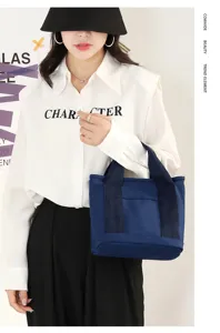 Casual dark blue canvas tote bag with front pocket and sturdy handles for daily use.