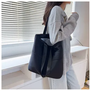 Detail view of a black nylon tote bag featuring large capacity and a sleek minimalist design.
