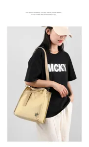 Beige canvas shoulder bag detail view, trendy casual crossbody handbag with adjustable strap.