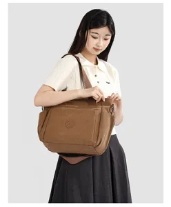 Gros plan sur le sac cabas en toile marron, montant un tissu résistant et sa poche.