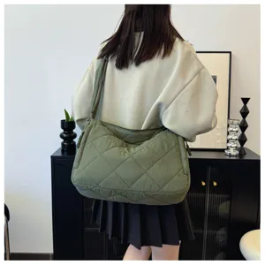 Green quilted shoulder bag detail shot, soft puffer tote bag showcasing texture and daily wear.