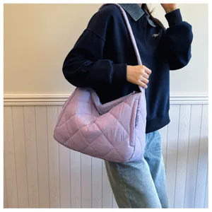Close-up detail view of the light purple quilted shoulder bag, showcasing soft puffer texture.