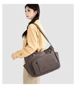 Canvas travel shoulder bag detail, vintage brown tote with multiple pockets and durable strap.