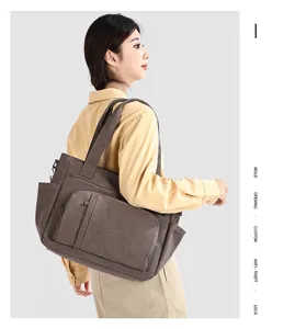 Detailed view of vintage canvas shoulder bag showing multiple pockets and dark brown fabric.