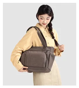 Detailed view of vintage brown canvas shoulder bag, large capacity tote with front pocket.