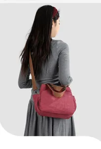 Detail view of casual canvas shoulder bag worn by model, showing durable textured fabric.
