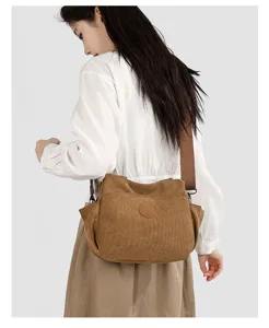 Detail view of brown retro canvas corduroy shoulder bag showing strap and texture.