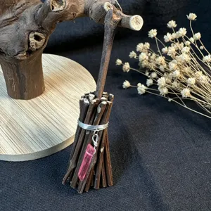 Handmade miniature twig broom ornament featuring a delicate pink crystal pendant, perfect decor.