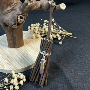 Close-up view of handmade witch crystal broom ornament, rustic twig detail and shimmering charm.