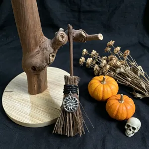 Mini witch broom Halloween decoration with sun pendant, rustic wooden stand and spooky props.