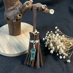 Handmade mini broom decorative ornament with green crystal pendant, delicate detail shot.