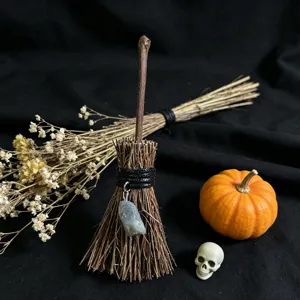 Miniature witch broom Halloween decoration with crystal stone pendant and natural dried plant fibers.