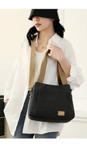 Casual black canvas shoulder bag with wide khaki strap, stylish daily crossbody bag detail.
