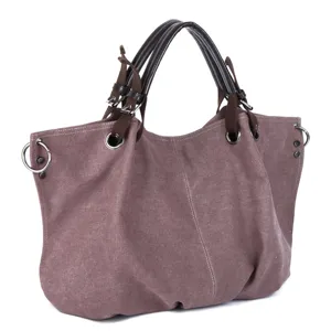 Detail view of large canvas hobo bag with dark brown handles and metal ring accents.