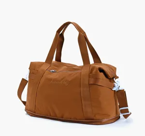 Details of brown travel duffel bag with shoulder strap, zipper pockets and durable fabric.