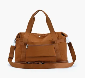 Detail view of brown travel duffel bag showing zipper pocket and durable shoulder strap.