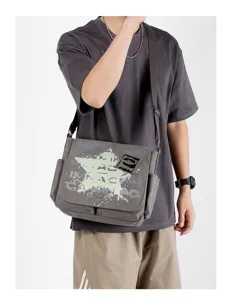 Detailed view of grey canvas messenger bag for men with stylish print and adjustable strap.