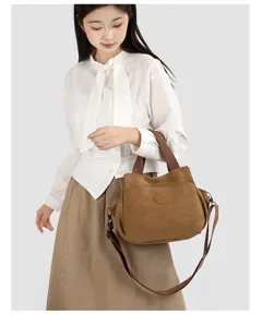 Detail view of a vintage canvas crossbody shoulder bag with sturdy brown handles and strap.