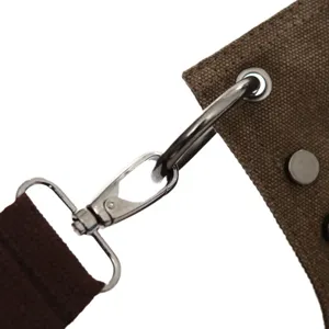Canvas bag metal hardware detail strap clasping brown fabric shoulder bag close-up display