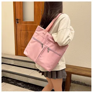 Detailed view of the stylish pink nylon tote bag with front zip pockets for daily use.