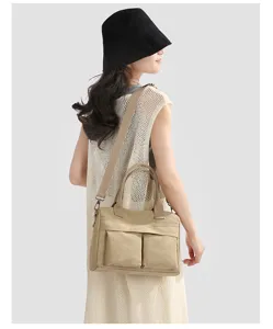 Canvas shoulder bag detail shot, showing khaki color, dual front pockets and durable strap.