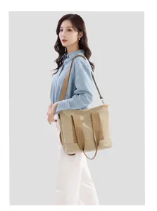 Detail view of the casual canvas tote bag worn by the model, featuring large capacity.