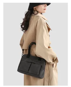 Detail shot of minimalist canvas crossbody bag with double front pockets and sturdy handles.
