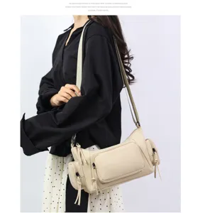 Bolso bandolera de nailon beis con múltiples bolsillos, vista detallada para uso diario.