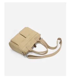 Detailed view of the casual canvas shoulder bag featuring dual front pockets and durable straps.