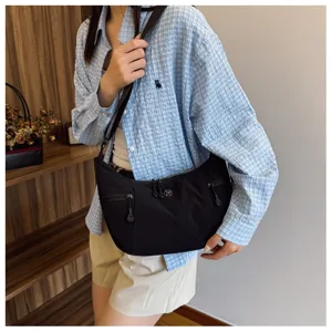 Detailed view of the black nylon messenger bag with zipper pockets and adjustable strap.