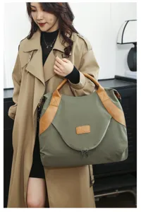 Large capacity nylon canvas shoulder bag with brown leather trim, detailed lifestyle shot.