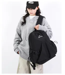 Detail view of the black pleated nylon backpack showing its unique drawstring and large capacity.