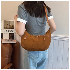 Casual nylon crossbody shoulder bag lifestyle detail view with practical zipper pockets.