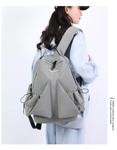 Detail of the casual grey nylon canvas backpack with unique pleated design and side pockets.