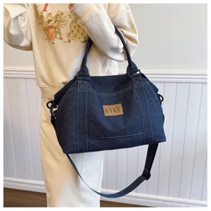 Vista dettagliata della borsa da viaggio in denim casual con grande capacità e manici resistenti.