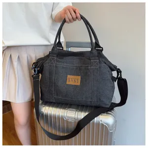 Vista dettagliata della borsa da viaggio in denim grigio scuro con grande capacita e cingh.