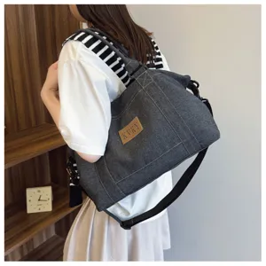 Dettaglio della borsa a tracolla in denim casual con capienza spaziosa e tessuto.