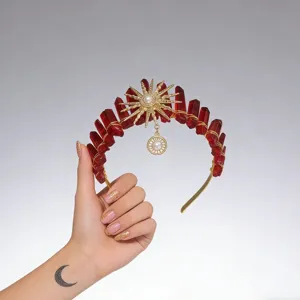 Close-up detail of the stunning red crystal sun crown headband with gold wire and pearl.