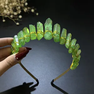 Detailed view of a green crystal crown headband with gold wire wrap for women photography.