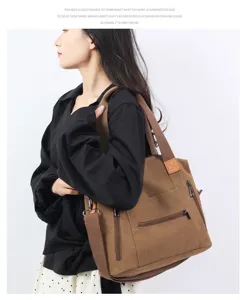 Canvas shoulder bag detail view showing front pocket and durable brown strap design