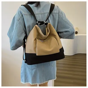 Detailed view of the stylish two-tone canvas backpack with front zipper pocket and straps.
