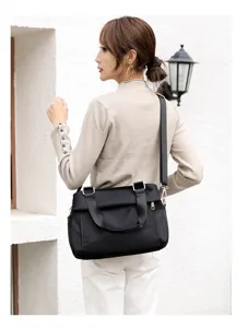Elegant black oxford cloth shoulder bag detail showing multi-layer design and comfortable strap.