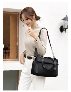 Detailed close-up view of a stylish black oxford cloth shoulder bag with multi layers.