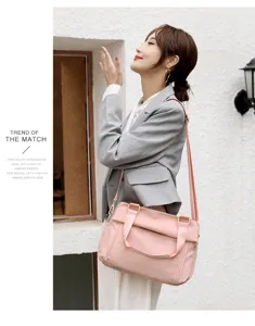 Detail shot of pink oxford cloth shoulder bag with multi-layer design and comfortable strap.