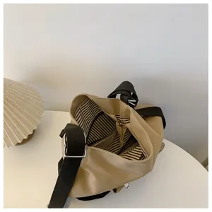 Stylish canvas shoulder bag for women, versatile multi-functional design with black straps.