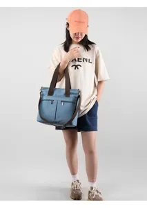 Casual blue canvas tote bag with brown straps, stylish crossbody shoulder bag for daily use.