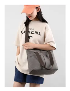 Casual grey canvas shoulder bag with brown straps, large capacity tote for daily commute.