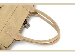 Canvas handbag detail close-up showing textured fabric handle and metal zipper design.